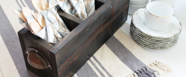 Wooden Silverware caddy sitting on top of placemats