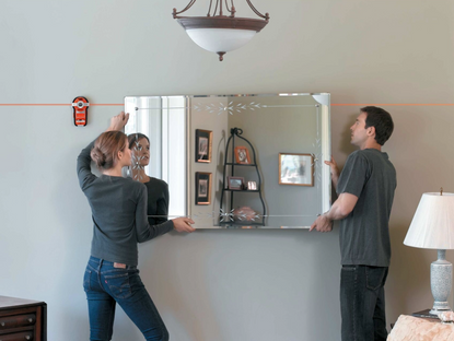 Couple using BLACK+DECKER laser pointer to hang a mirror