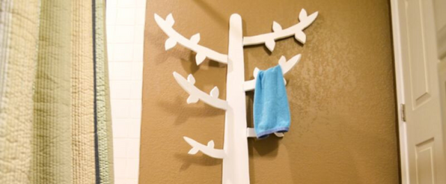 Tree-shaped towel hanger with a blue towel hanging from one of its branches