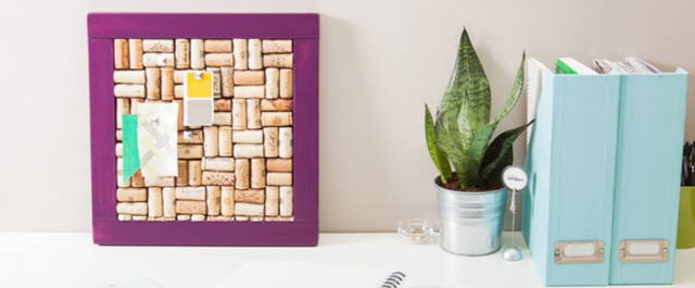 Wine corkboard on a table next to a plant and books