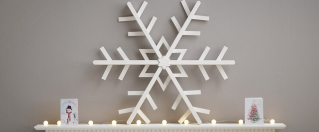 Large wooden snowflake on top of fireplace mantle