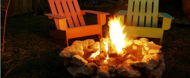 Two chairs sitting near Stone Fire Ring with bonfire burning