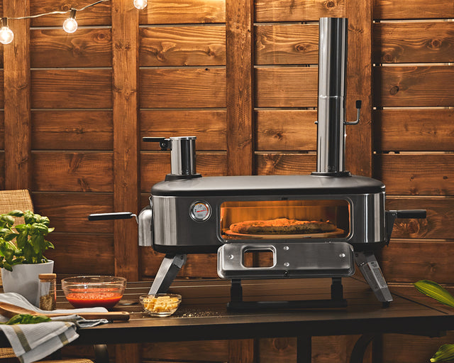 Pizza cooking inside of the BLACK+DECKER vera™ 12 in. pizza oven with the door open