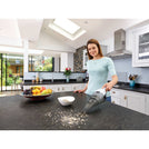 BLACK+DECKER Dustbuster quickclean cordless hand vacuum being used by a person to clean kitchen counter.